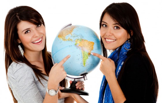 Dos mujeres sosteniendo flobo terraque apintando a América Latina