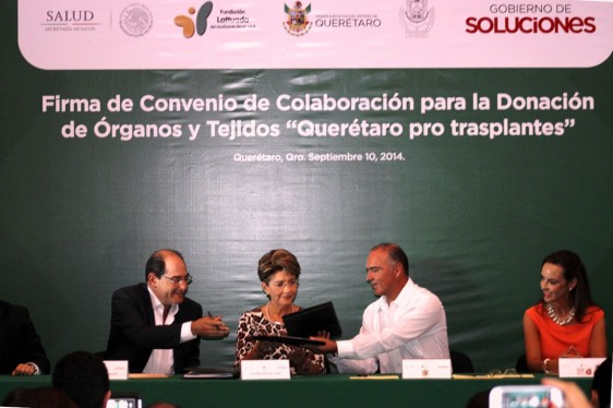 Jorge Lois Rodríguez, Mercedes Juan y José Eduardo Calzada Rovirosa sentados con otra persona firmando un documento