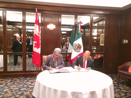 Dru Marshall y Sergio Alcocer firmando un documento