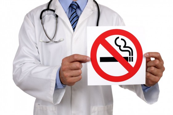 Doctor con letrero que contiene ilustración de no fumar