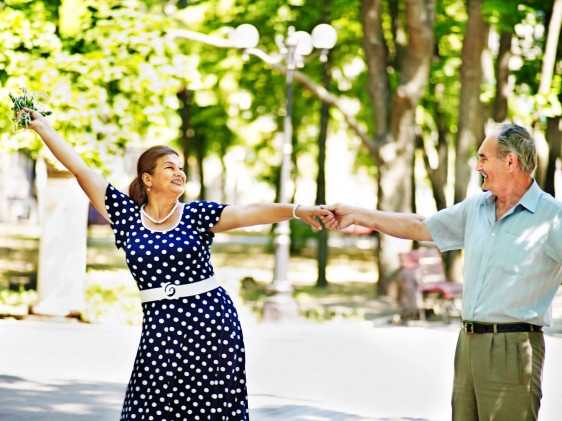 Dos adultos mayores bailando en un parque