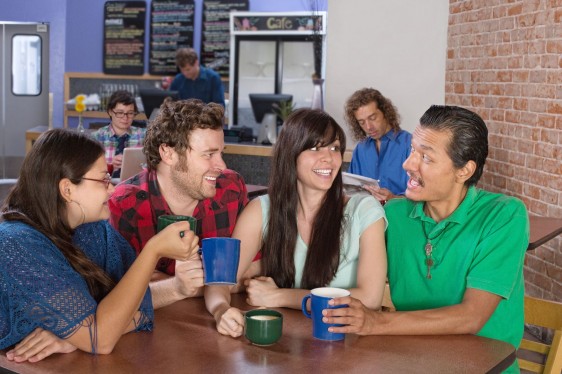 Grupo de amigos conversando en una cafetería
