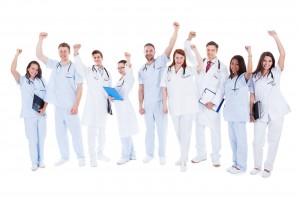Médicos con la mano en alto y expresión de alegría