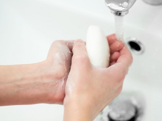 Acercamiento a las manos de una mujer lavándose las manos con agua y jabón