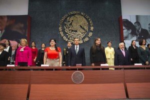 Funcionarios de pie al fondo el escudo nacional de los Estados Unidos Mexicanos