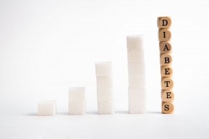 terrones de azúcar acomodados como grpafica de barras en crecimiento cubos de madera con la palabra diabetes son la columna mas grande
