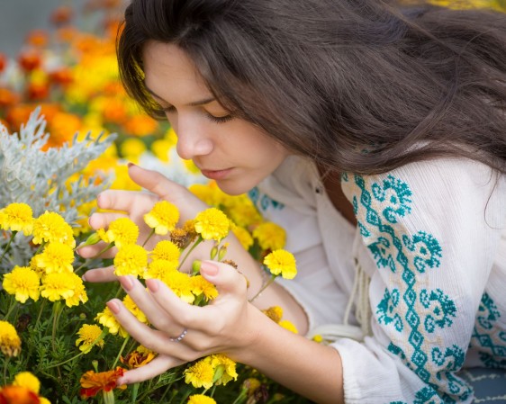 Una mujer oliendo flores