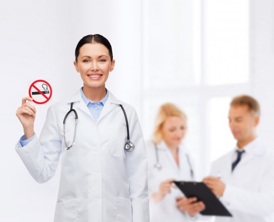 Doctora mostrando letrero de no fumar
