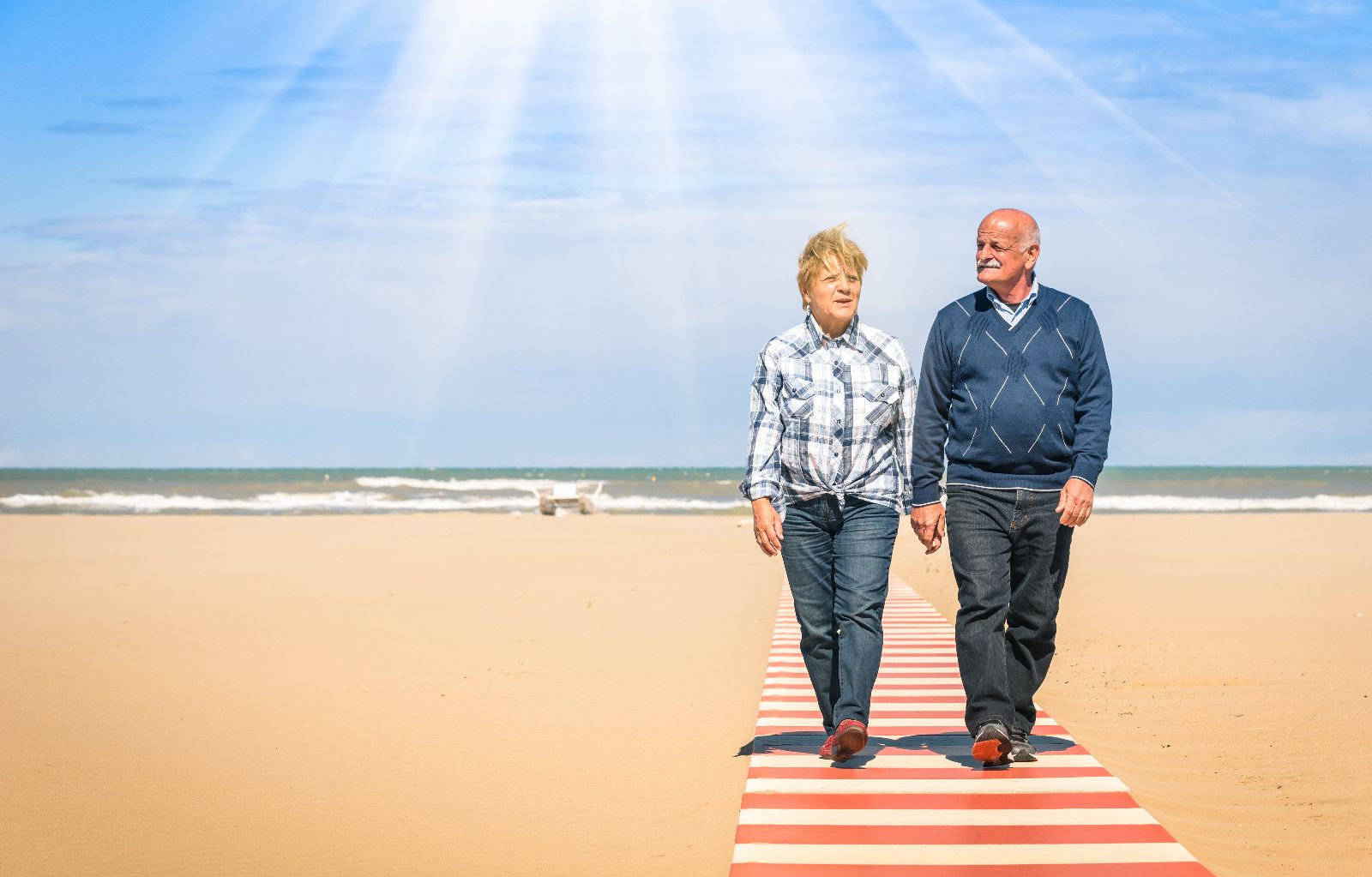 Adultos mayores caminando en una playa