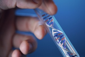 Una mano sosteniendo un tubo de ensayo en el interior una figura de ADN