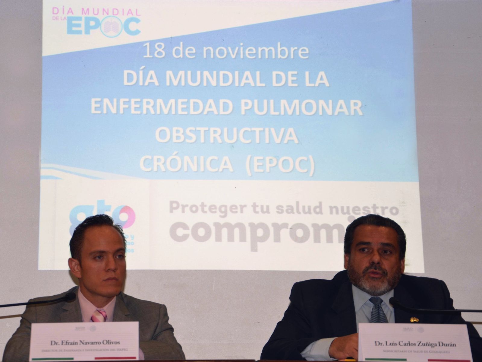 A la izquierda Efraín Navarro Olivos y a la derecha Luis Carlos Zúñiga Durán atras una proyección Día Mundial EPOC 18 de noviembre