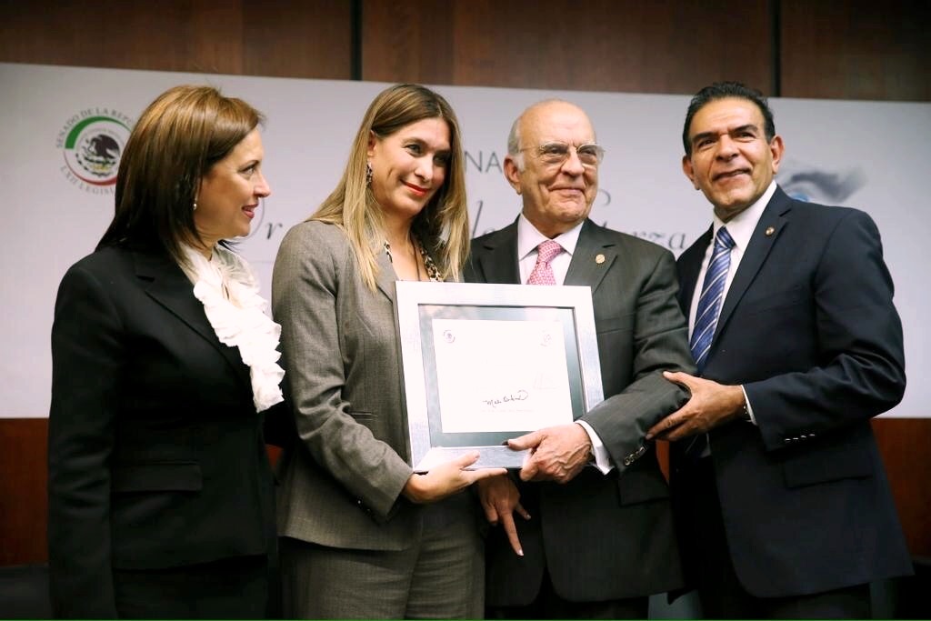 Jaime de la Garza recibieno reconocimiento de mano de los senadores