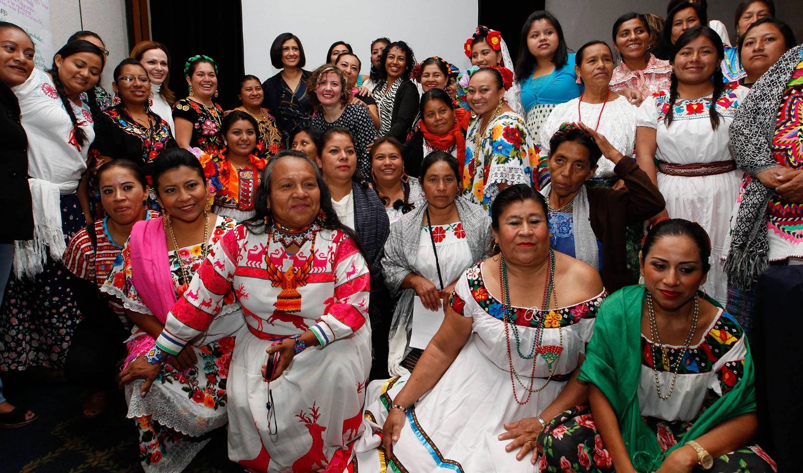 Grupo de mujeres sentadas mirando a fotografo