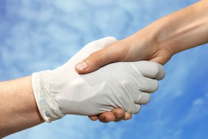 Apretón de manos de un médico con guantes de látex y un paciente
