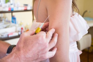 Aplican vacuna en el brazo de una adolescente