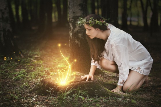 Mujer observa luces de hadas en un bosque mágico