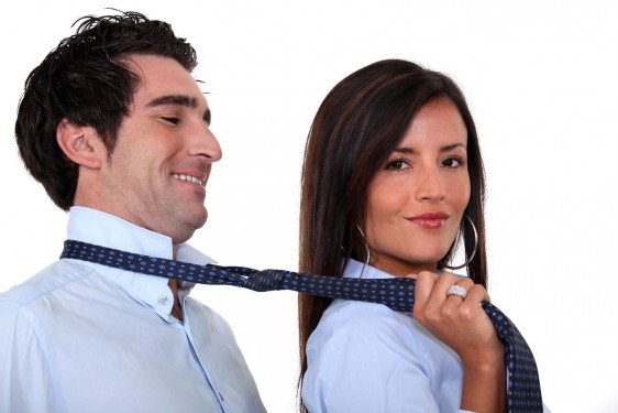 Mujer agarrando de la corbata a un hombre
