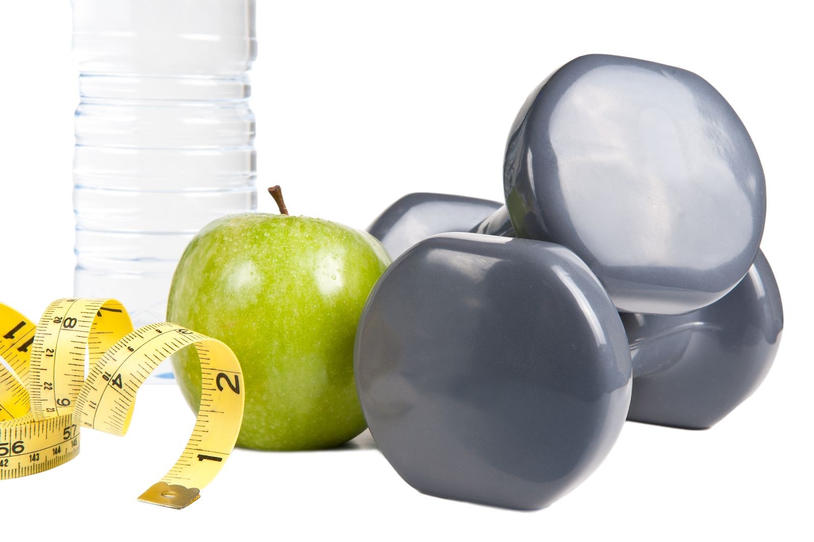 Agua, manzana y pesas con una cinta metrica