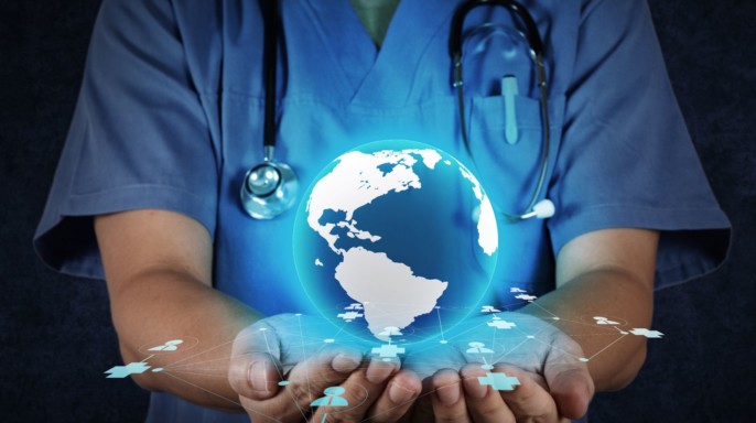 Médico sostiene ilustración de un holograma del mundo con iconos de médicos y salud