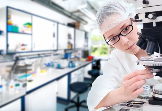 Mujer revisando microscopio en un laboratorio