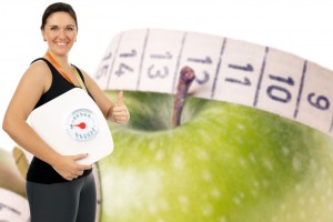 Mujer sosteniendo una bascula al fondo una manzana con cinta métrica