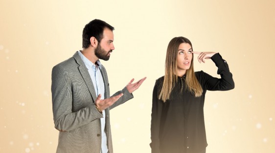 Himbre molesta al lado de una mujer haciendo un gesto de no comprender