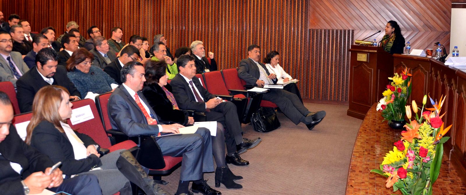 Funcionarios snetados en un auditorio escuchando un ponente