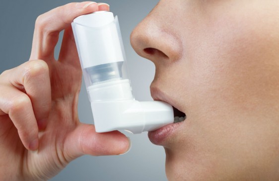 Mujer utilizando un inhalador blanco
