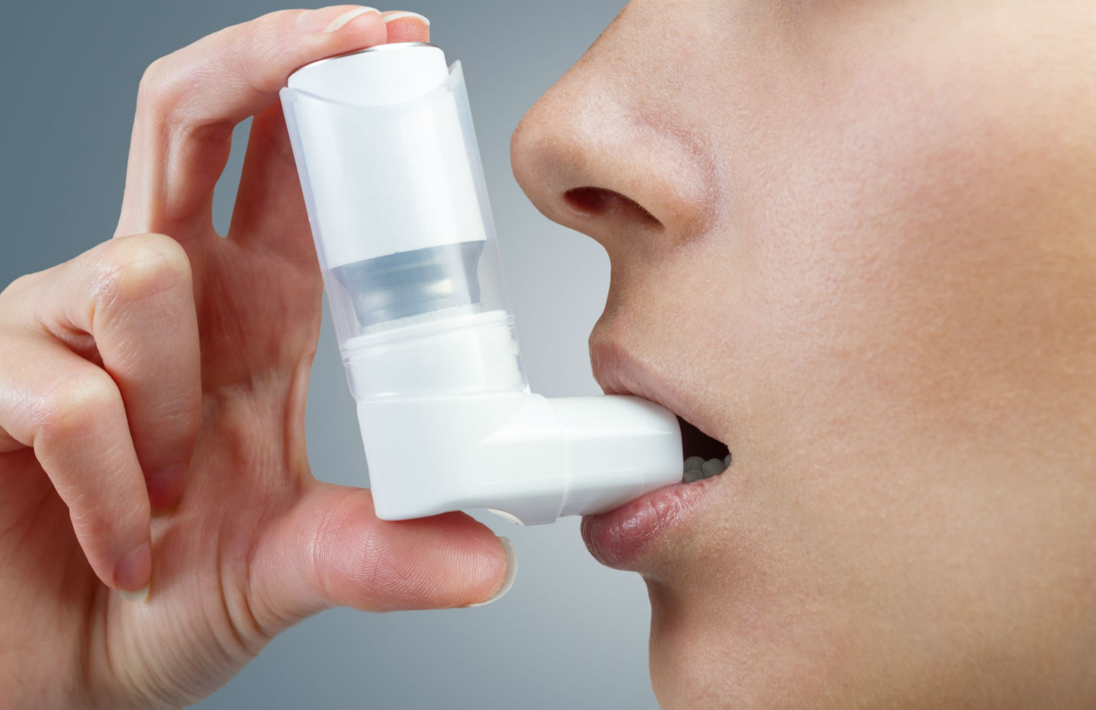 Mujer utilizando un inhalador blanco