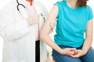 Mujer recibe inyección en el brazo aplicada por un médico