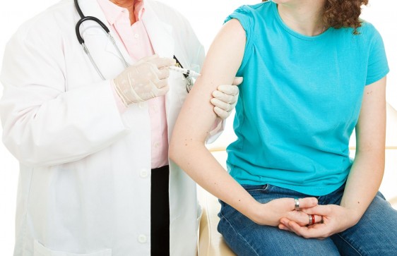 Mujer recibe inyección en el brazo aplicada por un médico