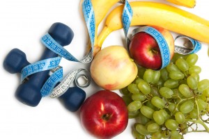 Frutas, cinta métrica y pesas para ejercicio
