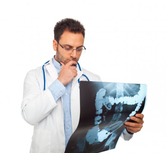 joven médico con estetoscopio observando radiografía