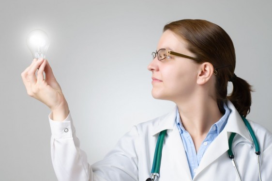 Doctora sostiene un foco encendido en la mano para ilisytar innovacipon