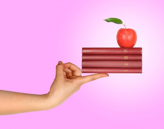 Mujer sosteniendo libros con una manzana