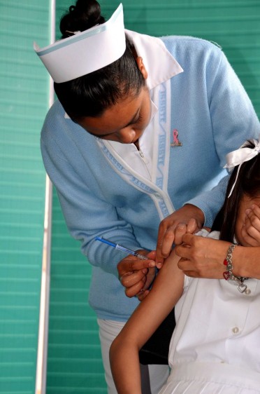 Enfermera aplicando vacuna a una niña