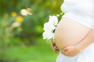 Mujer embarazada con una flor