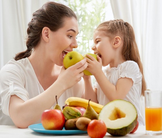 Madre e hija comiendo frutas