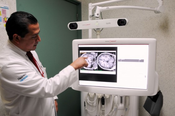 Médico apunta dedo a una pantalla que muestra un cerebro