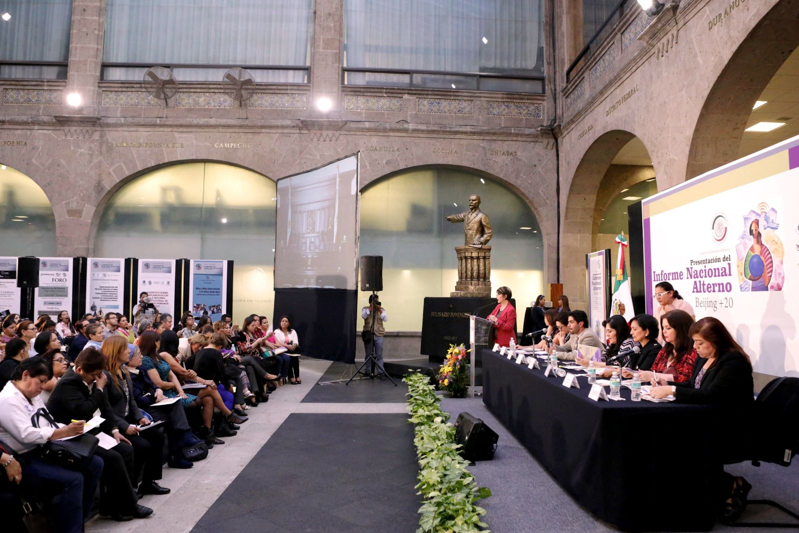 Foro y asistentes escuchando discurso en el Informe Nacional Alterno Beijing + 20