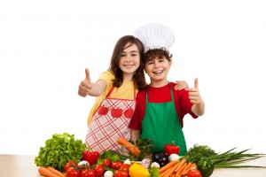 Niños con el dedo pulgar hacia arriba u enfrente con frutas y verduras