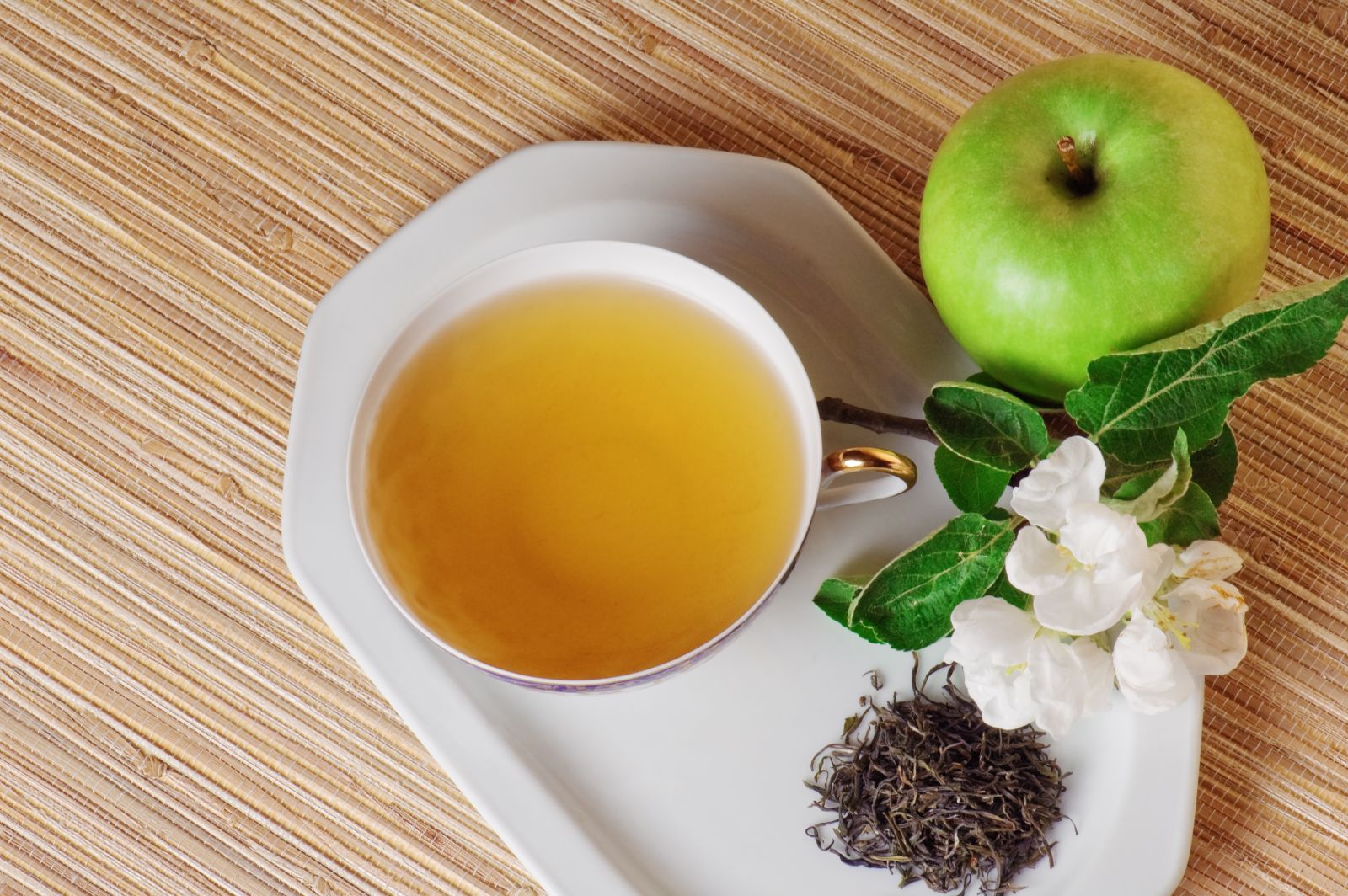 Taza con té Verde y una manzana al lado