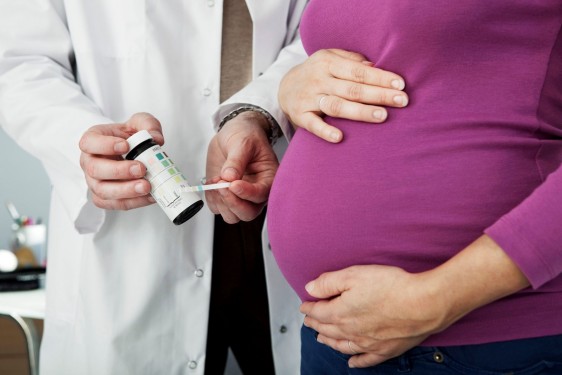 Médico ofrece tira de prueba a una mujer embarazada