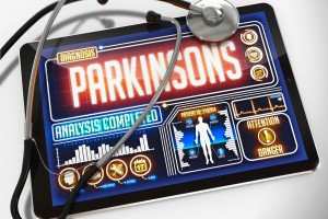 Estetoscopio al lado de una pantalla de computadora con una ilustracipon y la palabra "Parkinsons"