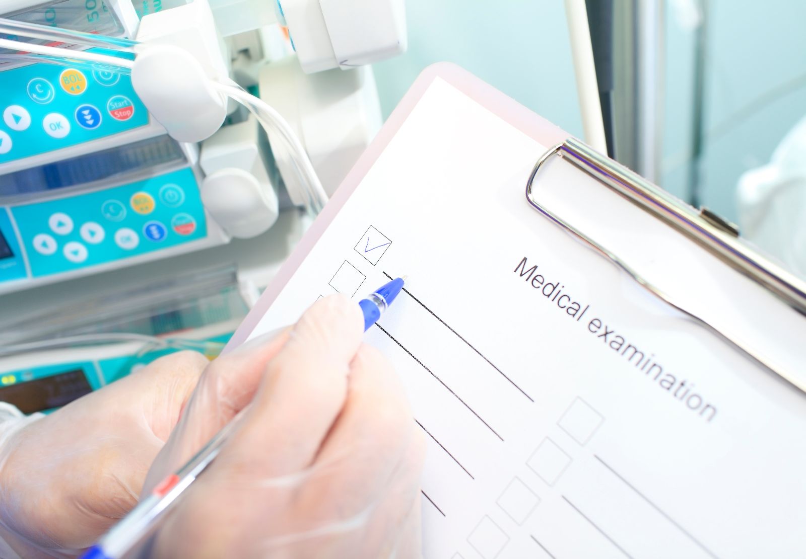 Acercamiento a las manos de un médico con guantes llenando documentación