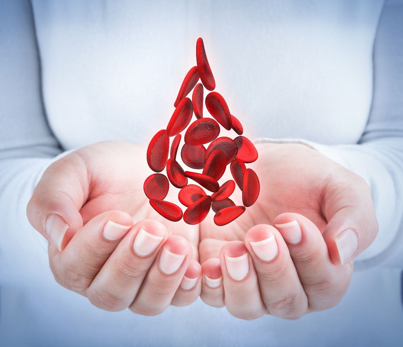 Mujer sosteniendo proyección 3D de una gota de sangre hecha con glóbulos rojos