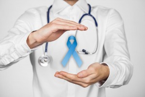 Médico con sus manos protege un listón azul para ilustrar protección del cáncer de próstata