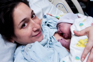 Mujer con bebé recién nacido en sus brazos