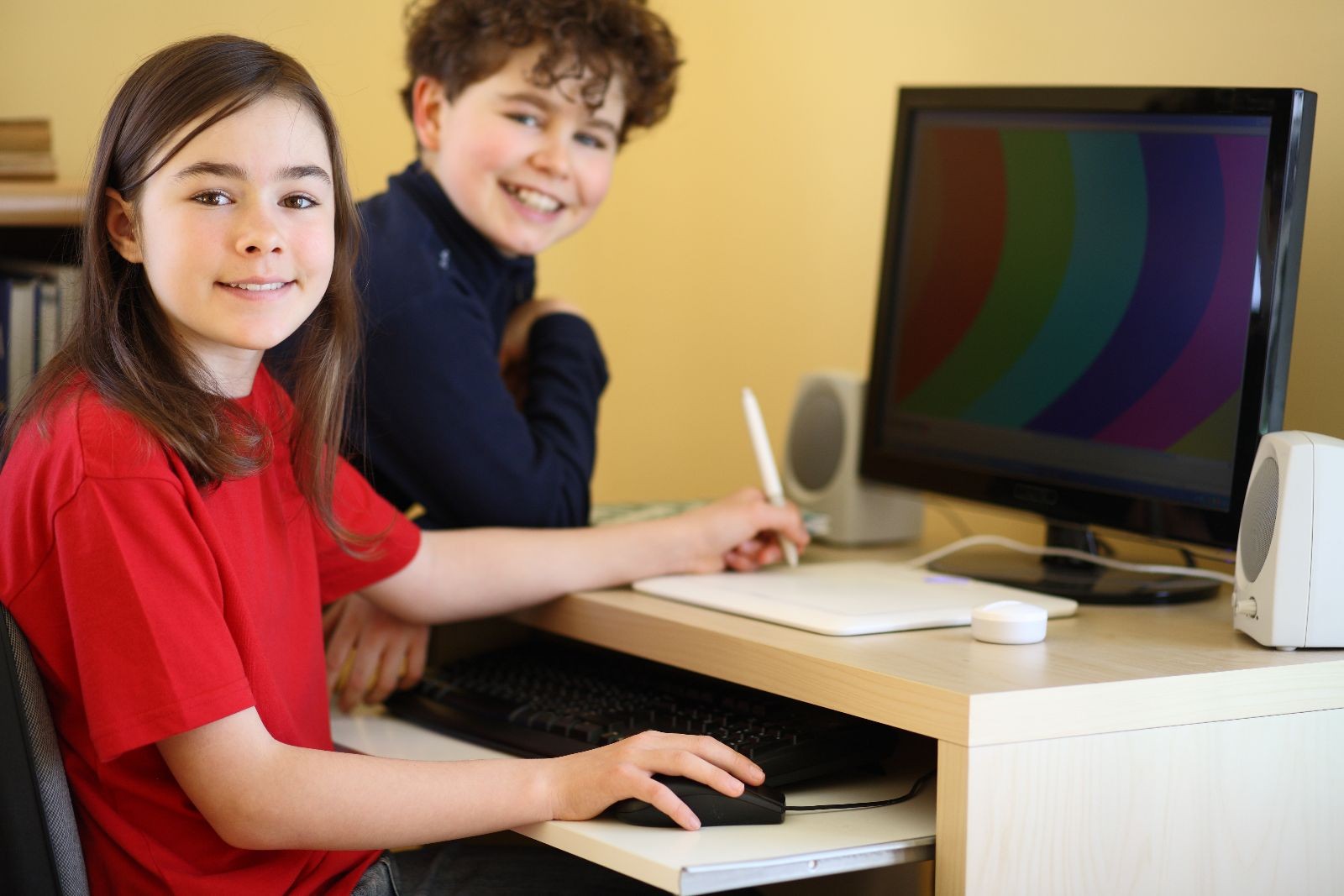 Niña y niño usando una computadora