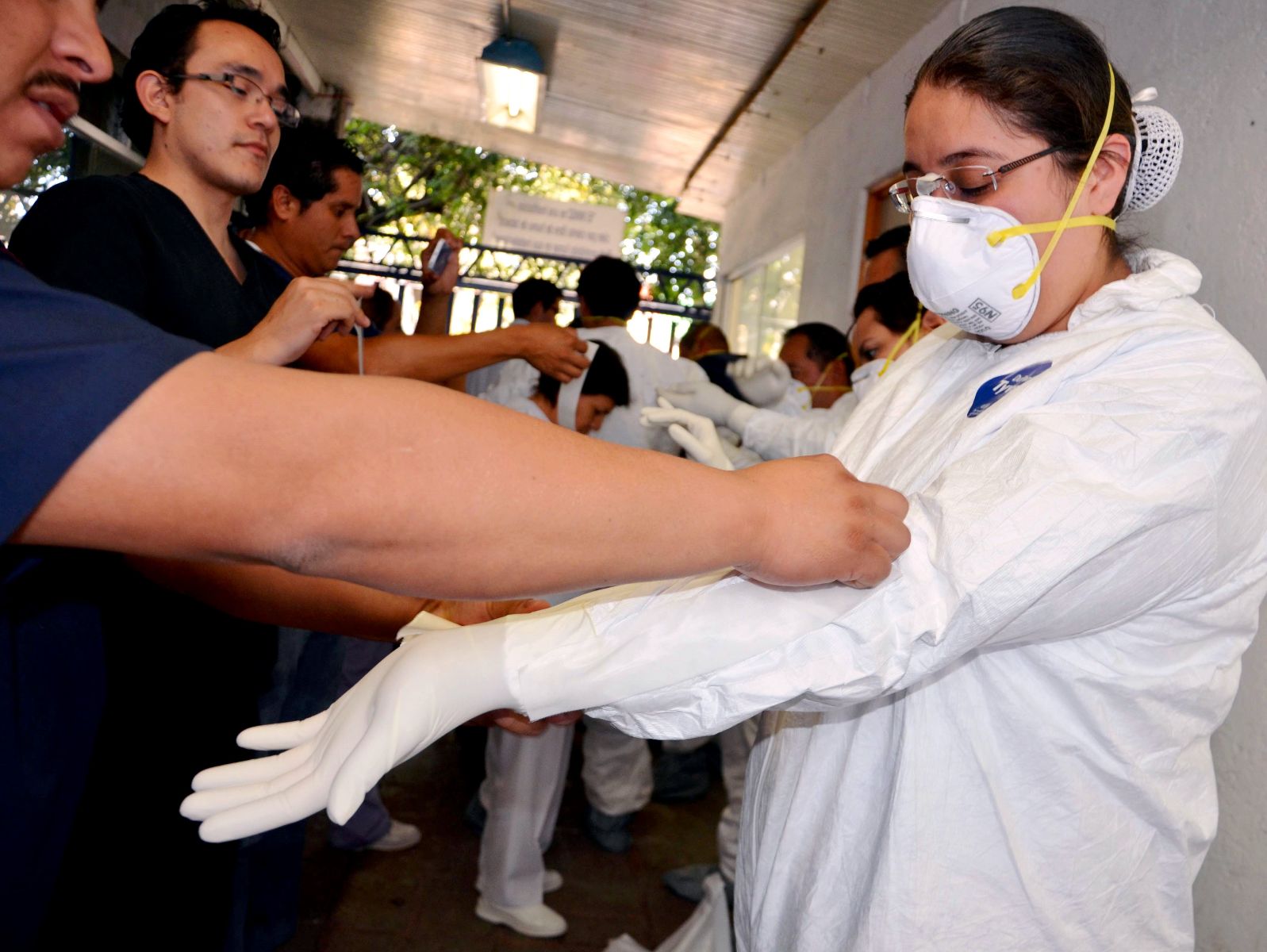 Equipo médico poniéndose equipo de protección